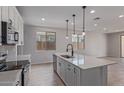 Bright kitchen with white cabinets, stainless steel appliances, quartz counters and pendant lighting over island at 18711 E Panchito Dr, Gold Canyon, AZ 85118