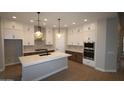 Modern kitchen with stainless steel appliances, an island with seating, and ample cabinet space at 6829 N 190Th Dr, Waddell, AZ 85355