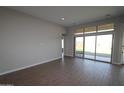 Bright living room with wood-look tile flooring and sliding glass doors leading to the backyard at 6829 N 190Th Dr, Waddell, AZ 85355