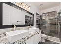 Modern bathroom featuring double sinks, granite counters, and a glass-enclosed shower at 520 S Brett St, Gilbert, AZ 85296