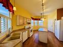 Bright eat-in kitchen featuring hardwood floors, tan cabinets, and stainless steel appliances at 9744 N 97Th Ln, Peoria, AZ 85345