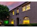 Charming two-story home with landscaped front yard and a tiled roof, illuminated by warm interior lighting at 955 S Henry Ln, Gilbert, AZ 85296