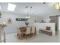 Bright dining room with neutral tones featuring skylight, modern light fixture, and sliding barn door at 1859 N Morris --, Mesa, AZ 85201