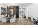 Elegant dining room featuring a modern chandelier and stylish wood accent wall at 10646 E Butherus Dr, Scottsdale, AZ 85255