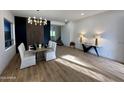 Modern dining room with a chandelier and seating for four, hardwood floors at 10646 E Butherus Dr, Scottsdale, AZ 85255