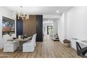 Elegant dining room featuring a modern chandelier and stylish wood accent wall at 10646 E Butherus Dr, Scottsdale, AZ 85255