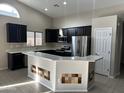 Spacious kitchen with dark cabinetry, stainless steel appliances, and an island at 44229 W Pioneer Rd, Maricopa, AZ 85139