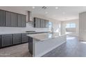 Modern kitchen featuring gray cabinets, quartz countertops, and tile floors at 20257 W Catalina Dr, Buckeye, AZ 85396