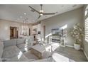 Bright, open living room featuring modern furnishings, neutral decor, and stylish ceiling fan at 23461 N 76Th Pl, Scottsdale, AZ 85255