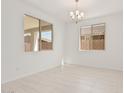 Well-lit living room featuring tile flooring, neutral paint, and contemporary chandelier at 5214 W Rainwater Dr, Laveen, AZ 85339