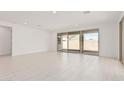 Spacious living room featuring tile flooring, neutral paint, and sliding glass doors at 5214 W Rainwater Dr, Laveen, AZ 85339