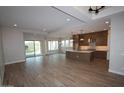 Bright open-concept living space with wood-look tile floors, recessed lighting, and a seamless flow to the kitchen at 21553 W Pierson St, Buckeye, AZ 85396
