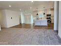 Open concept kitchen features island, modern appliances, and white cabinetry at 301 N Brower Rd, Maricopa, AZ 85139