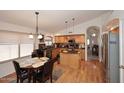 Open kitchen featuring stainless appliances, a central island, and wood floors flowing into the breakfast nook at 4506 E Lone Cactus Dr, Phoenix, AZ 85050