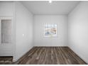 Well-lit living room with fresh white walls and wood-look vinyl flooring at 24586 W St Anne Ave, Buckeye, AZ 85326