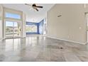 Spacious living area featuring tiled floors, high ceilings, and sliding glass doors that lead to an outdoor space at 16686 S 18Th Way, Phoenix, AZ 85048