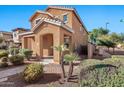 Two-story tan house with landscaped yard and walkway at 2090 S Moccasin Trl, Gilbert, AZ 85295