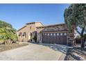 Charming stucco home with stone accents, a spacious driveway, and a two-car garage at 27587 N Makena Pl, Peoria, AZ 85383