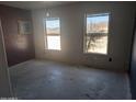 Unfinished bedroom with concrete floors and two large windows at 37909 W Raymond St, Tonopah, AZ 85354