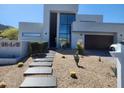 Modern home featuring desert landscaping, a pathway, and a minimalist architectural design at 18475 W Eagle Dr, Goodyear, AZ 85338