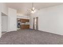 Spacious living room with neutral carpet, connecting to a kitchen with wood cabinets and a breakfast bar at 542 S Higley Rd # 99, Mesa, AZ 85206