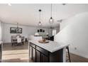 Open concept kitchen with eat in nook, pendant lighting, and black cabinets at 8913 E Oro Cir, Mesa, AZ 85212