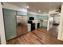 Spacious kitchen featuring stainless steel appliances, wooden floors, and stylish aqua cabinetry at 8241 N Central Ave # 24, Phoenix, AZ 85020