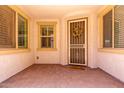 Inviting front porch with tiled flooring, security door, wreath, and warm, natural light at 10065 E Thatcher Ave, Mesa, AZ 85212