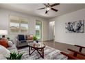 Airy living room featuring a ceiling fan, large windows, neutral paint, and contemporary decor at 10065 E Thatcher Ave, Mesa, AZ 85212