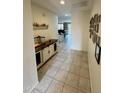 Hallway featuring tile flooring, neutral walls, and decor with a view to the kitchen at the end at 5636 W Jackalope Ln, Laveen, AZ 85339