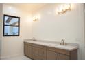 Bright bathroom featuring double sinks, a marble countertop, and gold fixtures for a luxurious feel at 3888 E Weston Ln, San Tan Valley, AZ 85140
