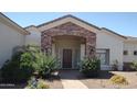 Inviting front entrance with stone archway, wood door, and lush landscaping for added curb appeal at 18029 W San Miguel Ave, Litchfield Park, AZ 85340