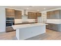 Spacious kitchen featuring modern appliances, a large island, and a stainless steel range hood at 28958 N 174Th Ln, Surprise, AZ 85387