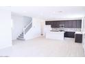 Open living space with light wood floors, white walls, staircase, and view of the modern kitchen at 2445 W Rowel Rd, Phoenix, AZ 85085