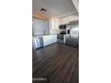 Bright kitchen boasts white cabinetry, stainless steel appliances, and dark laminate flooring at 6938 E Flossmoor Ave, Mesa, AZ 85208