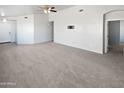 Neutral living room with carpet floors and ceiling fan, awaiting your personal touch at 6556 S 258Th Dr, Buckeye, AZ 85326