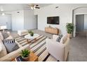 Bright living room featuring neutral tones, ceiling fan, stylish furniture, and modern decor at 6556 S 258Th Dr, Buckeye, AZ 85326