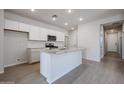 Modern kitchen with white cabinets, granite countertops, stainless steel appliances, and an island with a sink at 39980 W Bravo Dr, Maricopa, AZ 85138