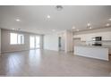 Open concept living space with ceramic tile flooring and sliding door access to the backyard at 39980 W Bravo Dr, Maricopa, AZ 85138