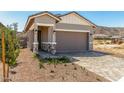 Home with two-car garage, stone accents, desert landscaping, and stucco at 5664 N 205Th Ln, Buckeye, AZ 85396