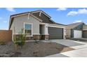 This is a single-story home with desert landscaping and a gray-colored 2-car garage at 16555 N Lunar St, Maricopa, AZ 85138
