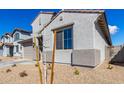 The exterior view of a modern home is showcased with its simple desert landscaping at 18440 W Monte Lindo Ln, Surprise, AZ 85387