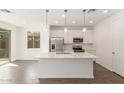 Bright kitchen featuring an island, stainless steel appliances, and white cabinetry at 11624 W Beck Dr, Youngtown, AZ 85363