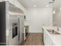 Close-up of a kitchen with stainless steel appliances, island, and white cabinets at 11624 W Beck Dr, Youngtown, AZ 85363