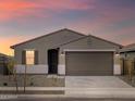 Evening shot of a single-Gathering home featuring a two-car garage and desert landscaping at 16001 W Cottontail Ln, Surprise, AZ 85387