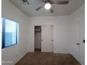 Bright bedroom with ceiling fan, window blinds, and spacious closet at 812 W Saint Anne Ave, Phoenix, AZ 85041