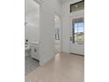 Bright entryway featuring neutral tile floors, a half-bath, and a glimpse into the adjacent living space at 4405 N 203Rd Ave, Buckeye, AZ 85396