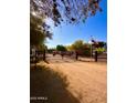 A long driveway leads to a home, highlighted by an Arizona state flag and decorative fencing at 7706 N 173Rd Ave, Waddell, AZ 85355