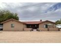 Charming single-story home with a red tile roof and neutral stucco, surrounded by desert landscaping at 7706 N 173Rd Ave, Waddell, AZ 85355