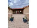 Inviting front entrance with a red door, covered porch, brick accents and desert plants at 7706 N 173Rd Ave, Waddell, AZ 85355